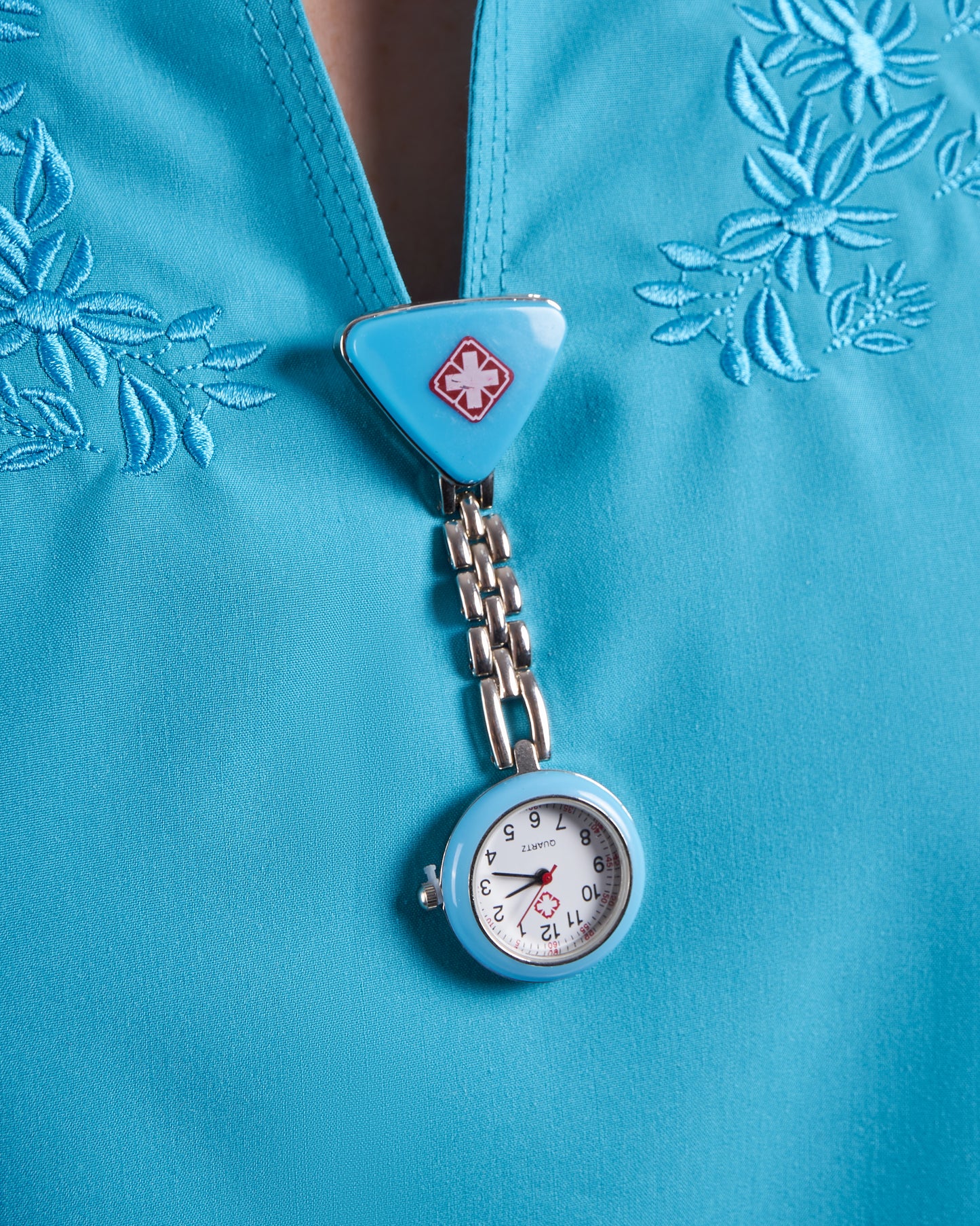 Reloj prendedor cruz triangular