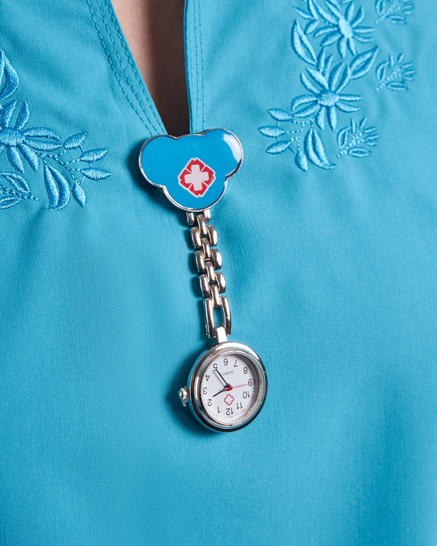 Reloj prendedor cruz gorrito